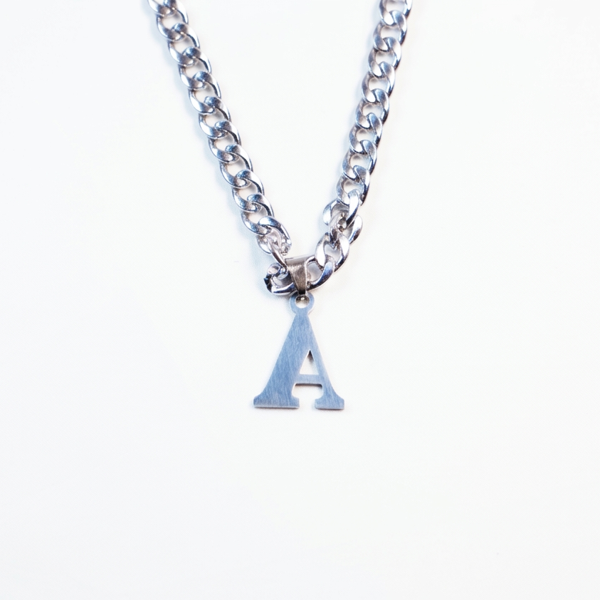Silver necklace with a small letter 'A' pendant on a white background