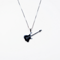 Guitar-shaped pendant on a chain against a white background