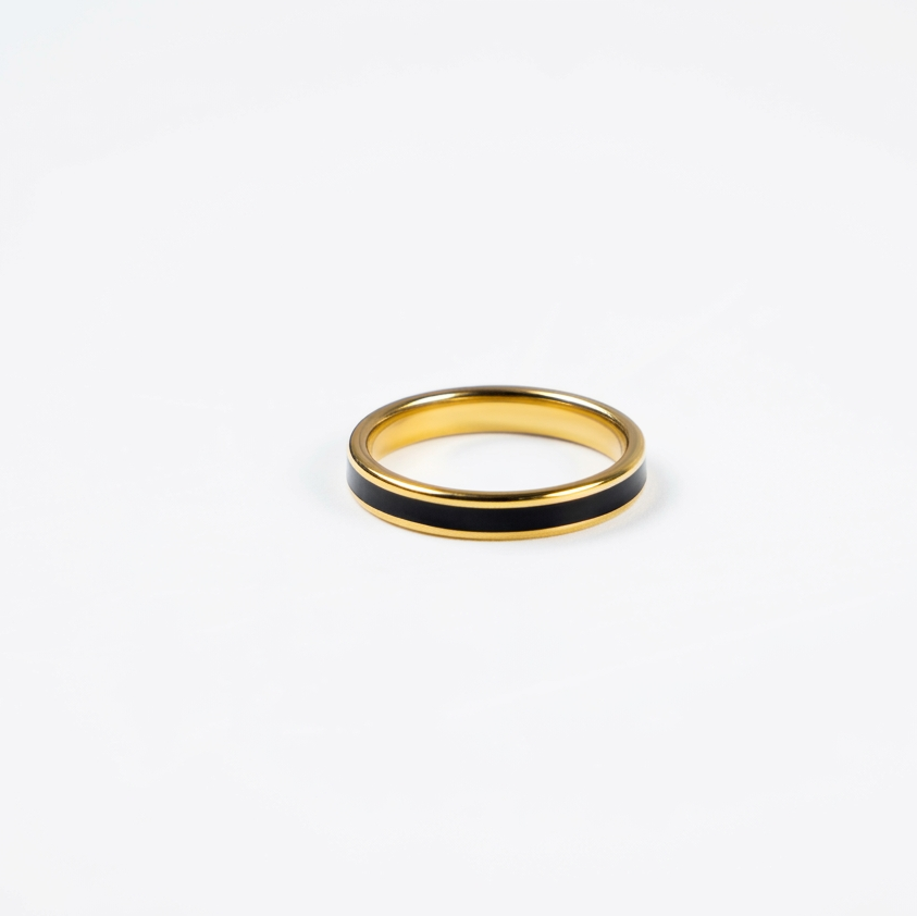 Gold ring with black band on a white background